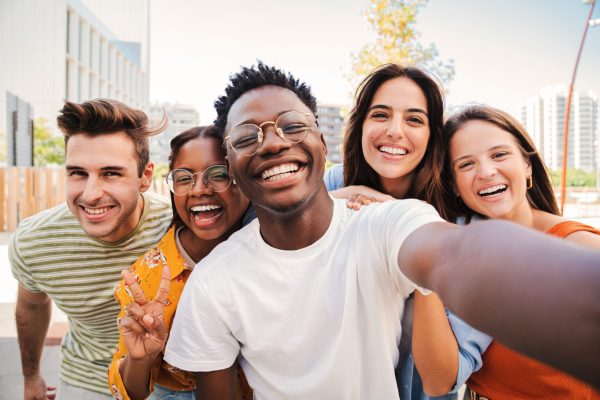 Group of multiracial young student people smiling and taking a selfie together. Close up portrait of happy african american teenager laughing with his cheerful friends. Classmates on friendly meeting. High quality photo